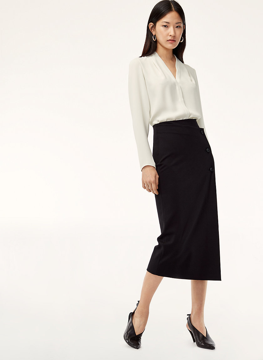 Model styled in white dress shirt and black skirt