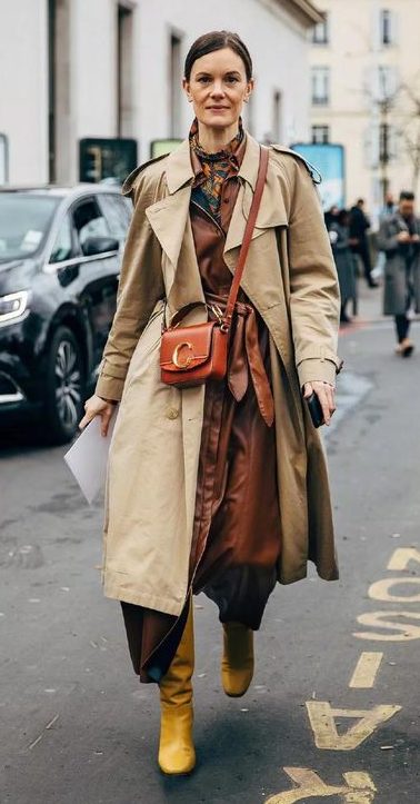 White model walking down the street in an oversized trench coat