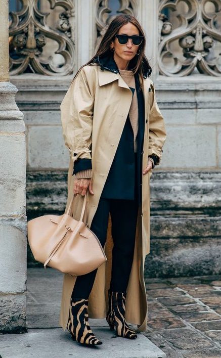 Tanned model in oversized brown trench coat