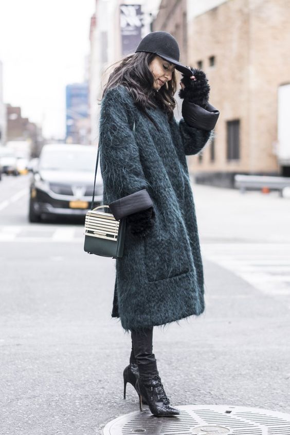 Dark-haired model styled in fuzzy grey coat with black high heels