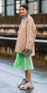 Dark-haired model wearing an oversized sweater with sneakers