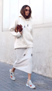 White model wearing a white hoodie with red and white sneakers
