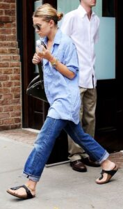 Blonde women in blue outfit and black sandals walking