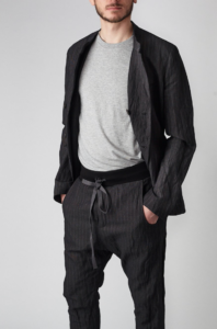 White male model styled in black jacket with black pants