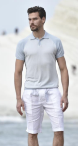 White male model styled in white polo shirt and white shorts