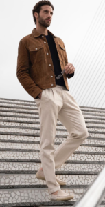 White male model styled in brown jacket with white pants