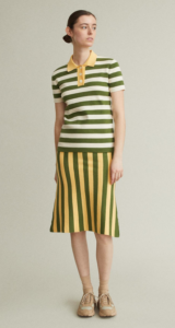 Brunette female model styled in a green-striped shirt with a yellow-striped skirt