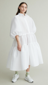 Brunette female model styled in a puffy white dress
