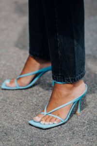 Woman wearing pair of light blue, heeled sandals