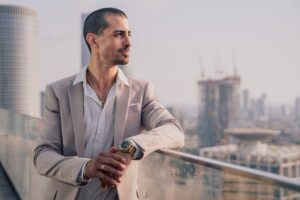 Stylish man in fitted tux looking over balcony